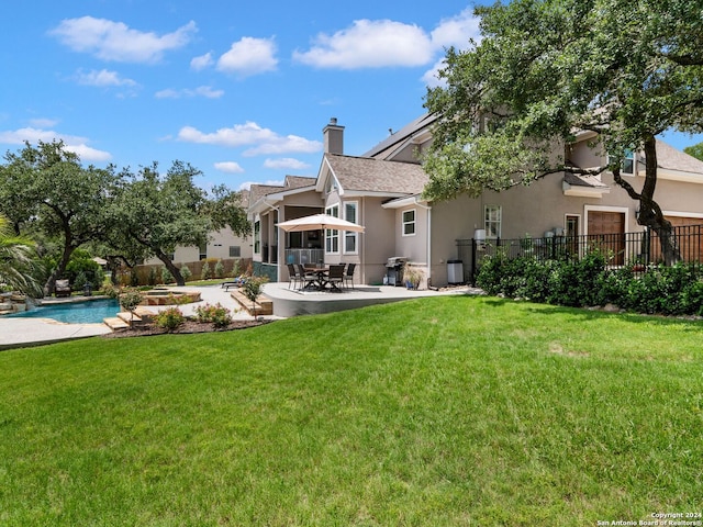 rear view of property featuring a fenced in pool, a yard, and a patio