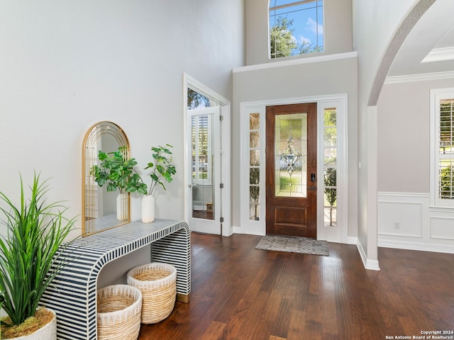 foyer entrance with dark wood-type flooring and ornamental molding