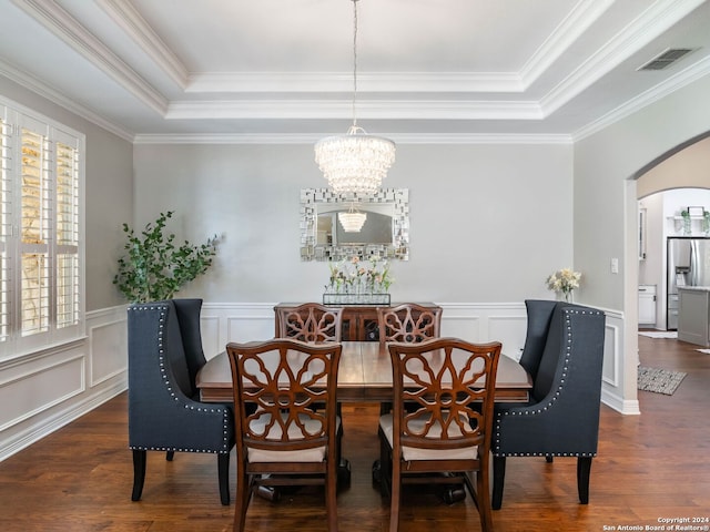 dining area featuring crown molding, a tray ceiling, and dark hardwood / wood-style floors