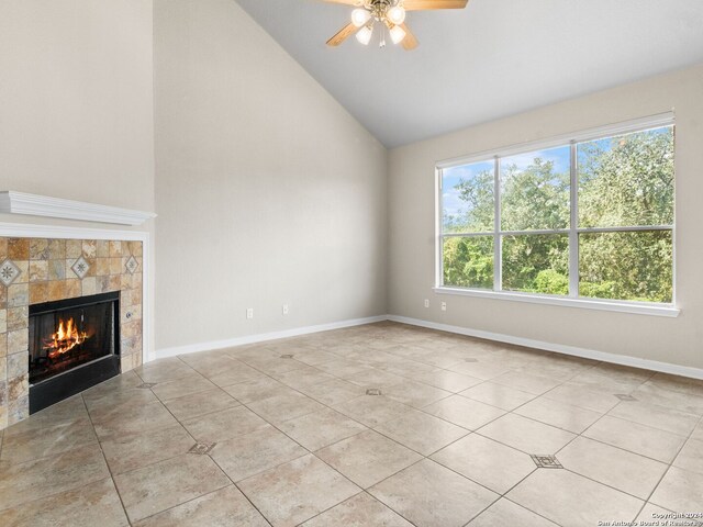 unfurnished living room with a fireplace, high vaulted ceiling, ceiling fan, and light tile patterned flooring