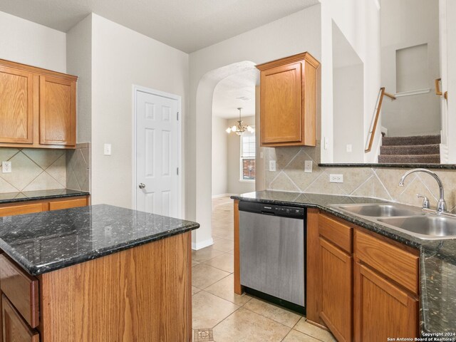 kitchen featuring light tile patterned flooring, stainless steel dishwasher, sink, and backsplash