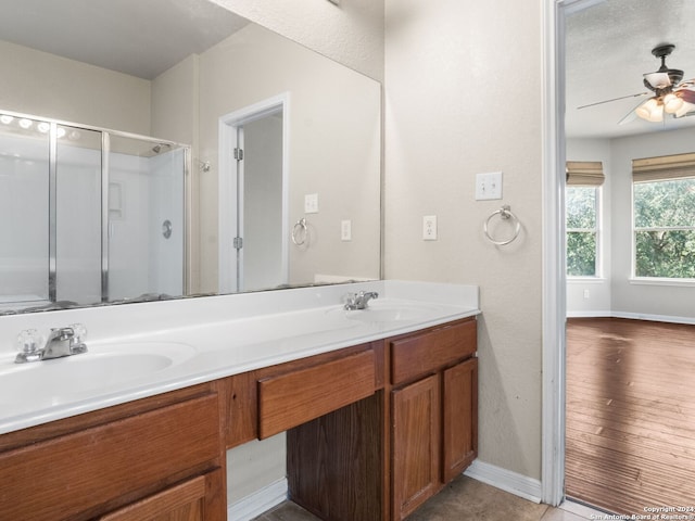 bathroom with tile patterned flooring, vanity, ceiling fan, and walk in shower