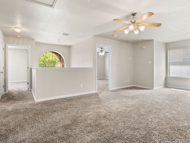 spare room with light carpet and a textured ceiling