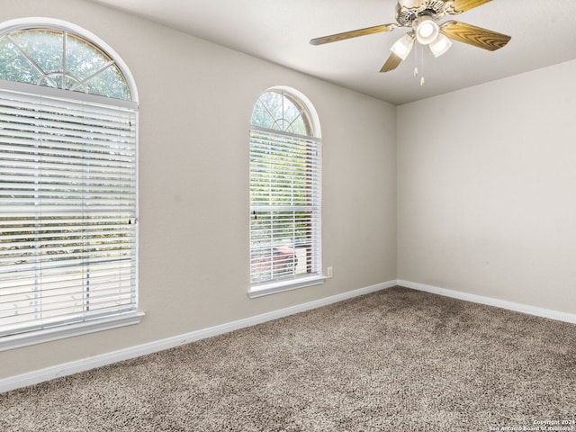 carpeted spare room with ceiling fan