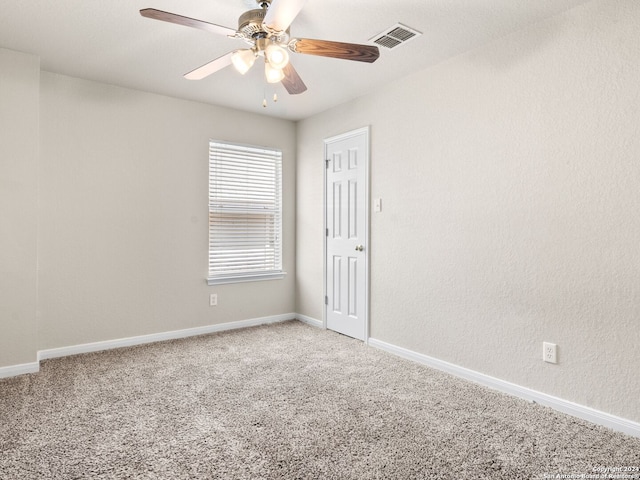 carpeted spare room featuring ceiling fan