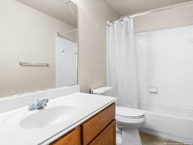 full bathroom featuring shower / bath combination with curtain, vanity, toilet, and a textured ceiling