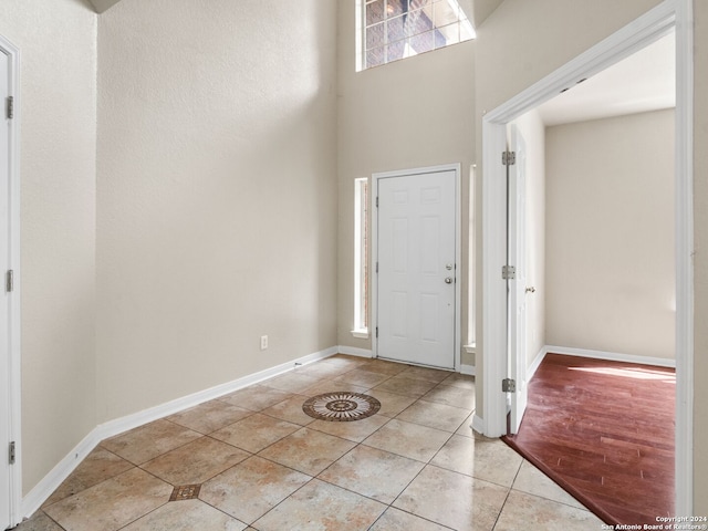 entrance foyer featuring a towering ceiling and light tile patterned floors