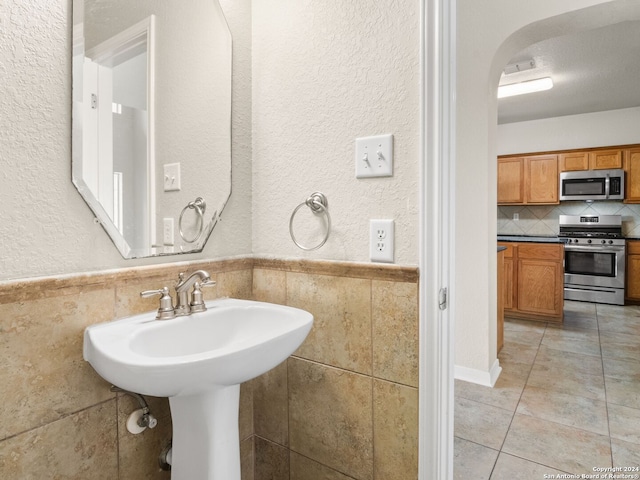 bathroom with tile patterned floors and tile walls