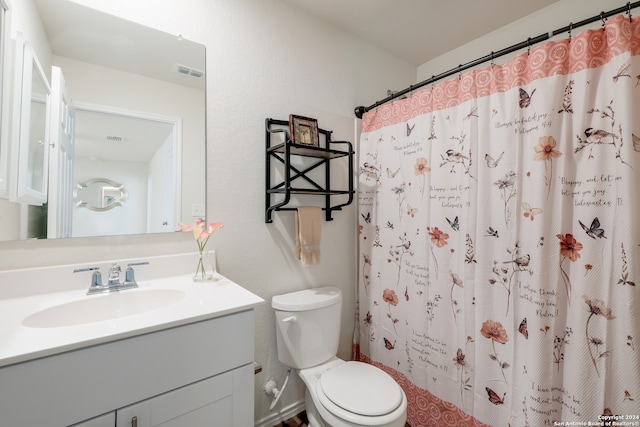 bathroom featuring vanity, toilet, and curtained shower