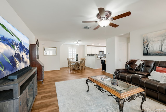 living room featuring light wood-type flooring and ceiling fan