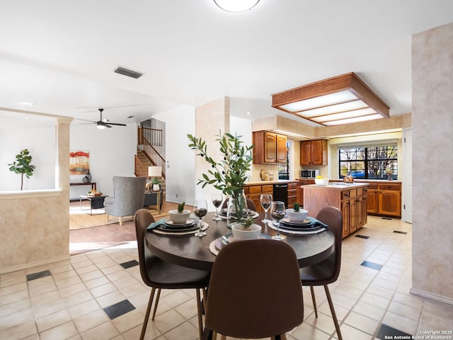 tiled dining space with ceiling fan