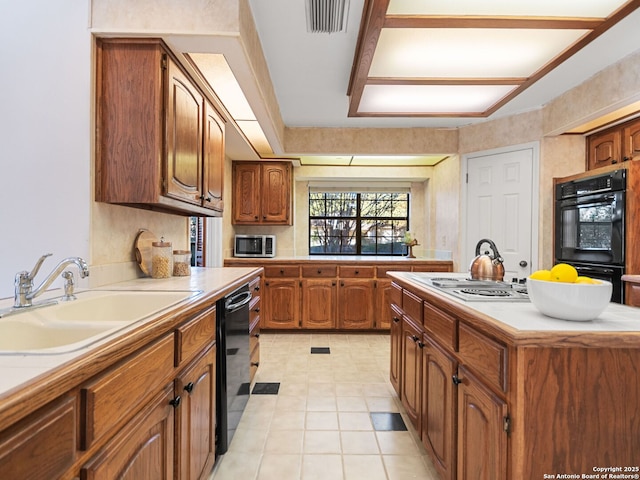 kitchen with light tile patterned floors, sink, a kitchen island, and black appliances