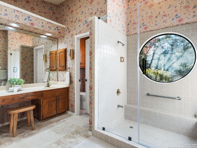 bathroom with vanity, toilet, and an enclosed shower