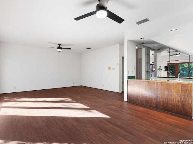 unfurnished living room with dark hardwood / wood-style floors, sink, and ceiling fan