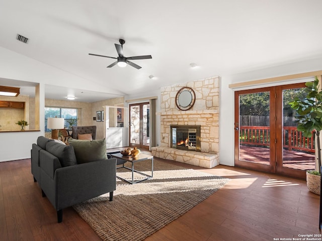 living room with a fireplace, vaulted ceiling, dark hardwood / wood-style floors, and plenty of natural light