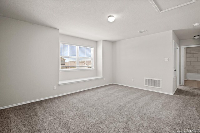 unfurnished room with a textured ceiling and carpet floors