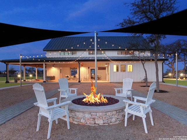 patio at night featuring an outdoor fire pit