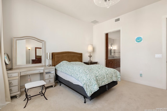 bedroom with light colored carpet, an inviting chandelier, and ensuite bath