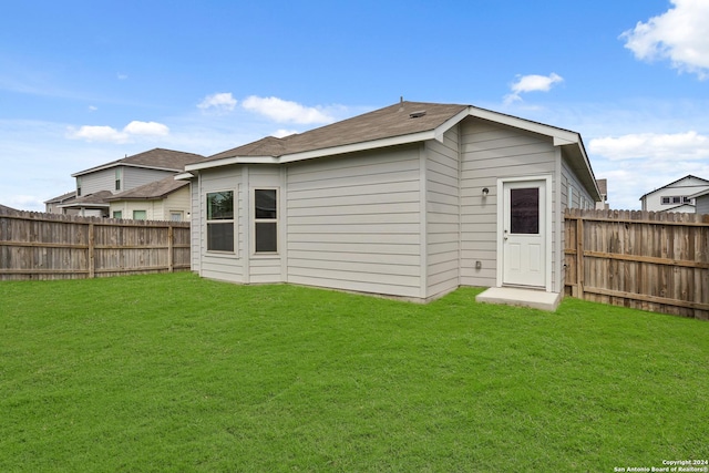 rear view of property featuring a lawn