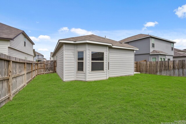 rear view of property with an outbuilding and a yard