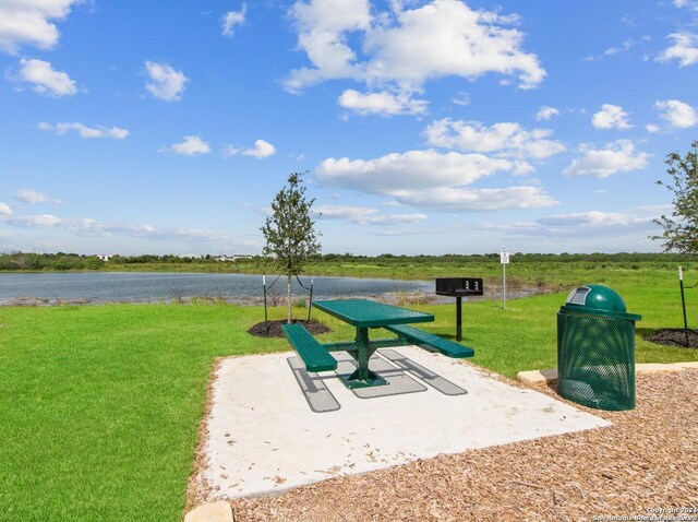 view of property's community with a water view and a yard