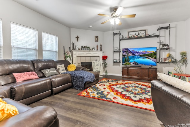 living room featuring a fireplace, dark hardwood / wood-style floors, and ceiling fan