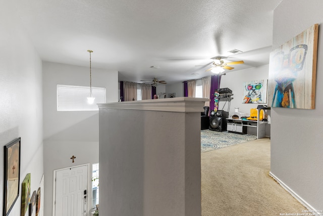 corridor featuring a textured ceiling and carpet flooring