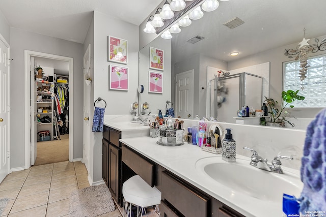 bathroom featuring an enclosed shower, double sink vanity, a textured ceiling, and tile patterned flooring