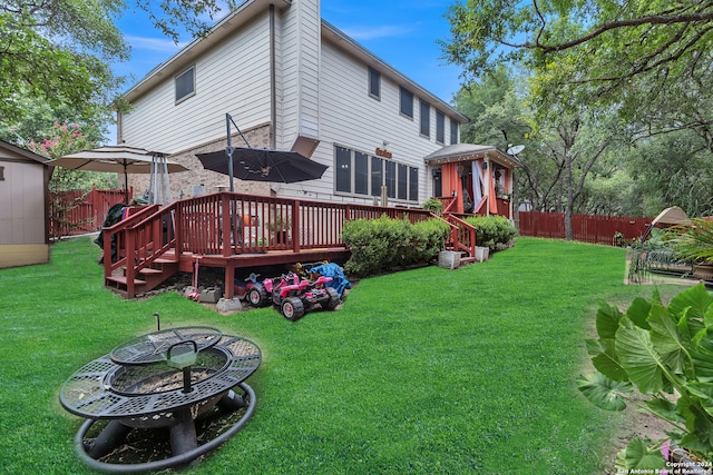 rear view of house with a lawn and a deck