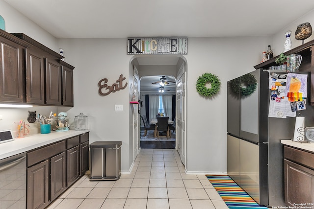 kitchen with appliances with stainless steel finishes, dark brown cabinets, light tile patterned floors, and ceiling fan