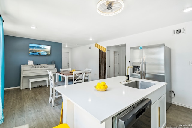 kitchen with light hardwood / wood-style flooring, black dishwasher, an island with sink, and sink