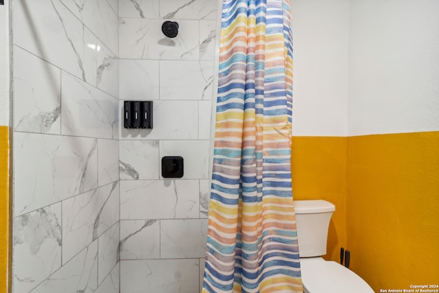 bathroom featuring curtained shower and toilet