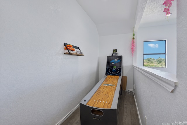 game room with a textured ceiling, vaulted ceiling, and dark hardwood / wood-style floors