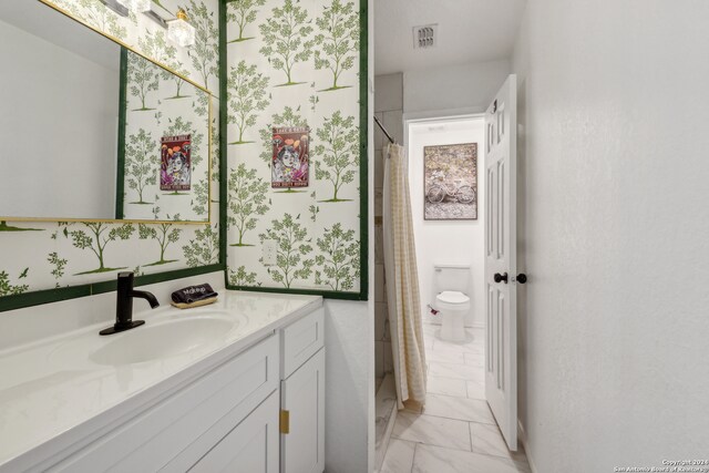 bathroom featuring vanity, toilet, and walk in shower