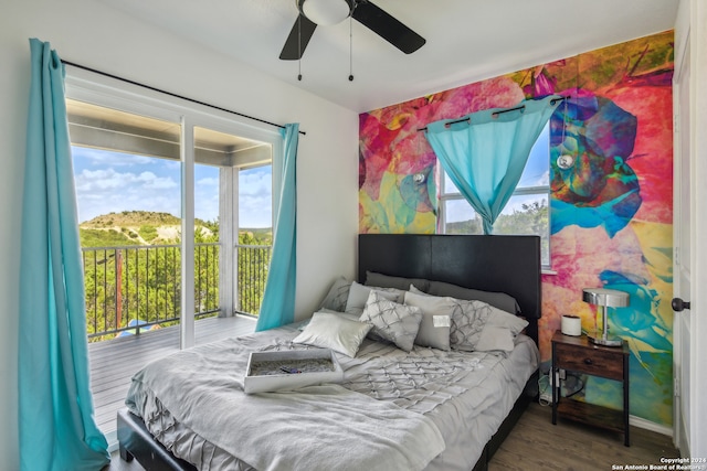 bedroom featuring multiple windows, access to exterior, ceiling fan, and dark hardwood / wood-style floors