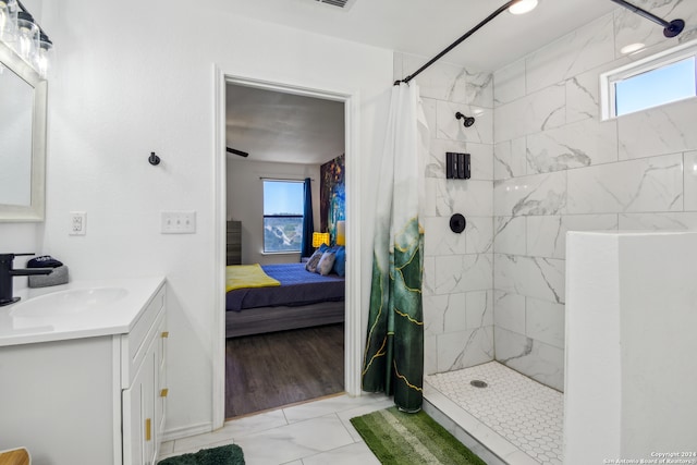 bathroom featuring vanity, hardwood / wood-style flooring, walk in shower, and a healthy amount of sunlight