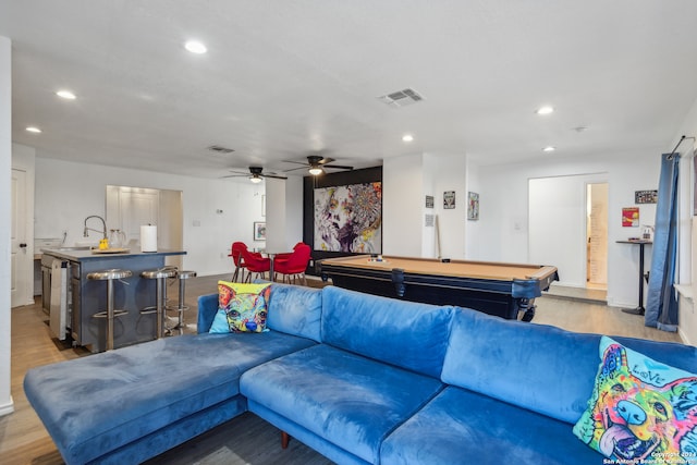 living room with billiards, ceiling fan, wet bar, and light hardwood / wood-style flooring