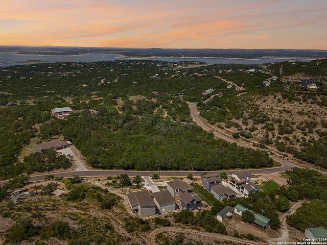 aerial view at dusk featuring a water view