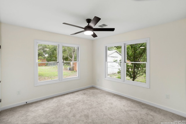 spare room featuring light carpet and ceiling fan