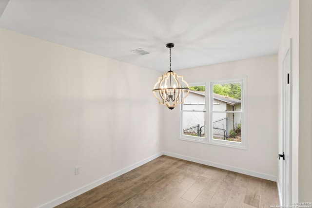 unfurnished dining area featuring a notable chandelier and light hardwood / wood-style flooring