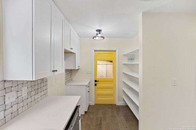 kitchen with decorative backsplash, white cabinets, and dark hardwood / wood-style floors