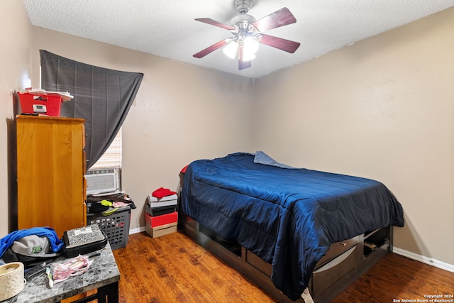 bedroom featuring ceiling fan, wood-type flooring, a textured ceiling, and cooling unit