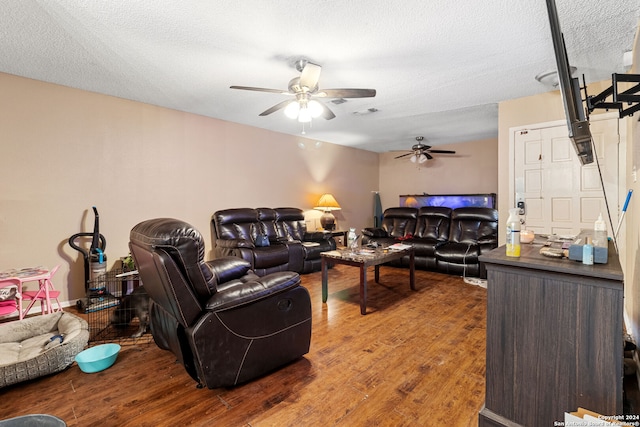 living room with ceiling fan, wood-type flooring, and a textured ceiling