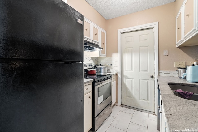 kitchen with white cabinetry, black refrigerator, light tile patterned floors, electric stove, and tasteful backsplash