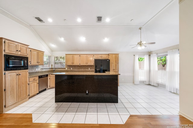 kitchen featuring tasteful backsplash, light hardwood / wood-style flooring, a healthy amount of sunlight, black appliances, and a kitchen island