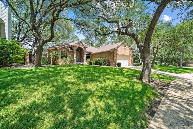 ranch-style home with an attached garage, driveway, a front lawn, and brick siding