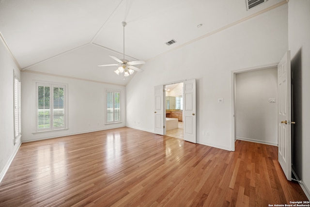 unfurnished bedroom featuring ensuite bath, hardwood / wood-style floors, high vaulted ceiling, ceiling fan, and ornamental molding