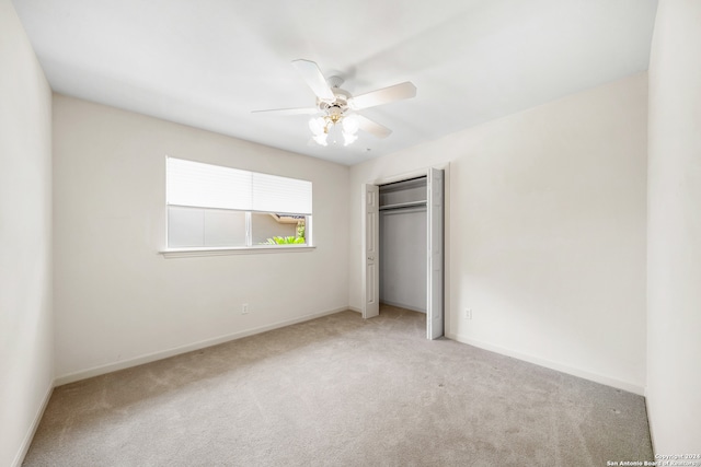 unfurnished bedroom featuring ceiling fan, light carpet, and a closet