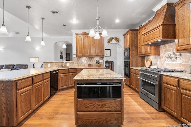 kitchen with black appliances, decorative backsplash, light hardwood / wood-style flooring, and custom exhaust hood