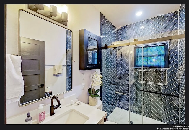 bathroom featuring an enclosed shower, toilet, and vanity